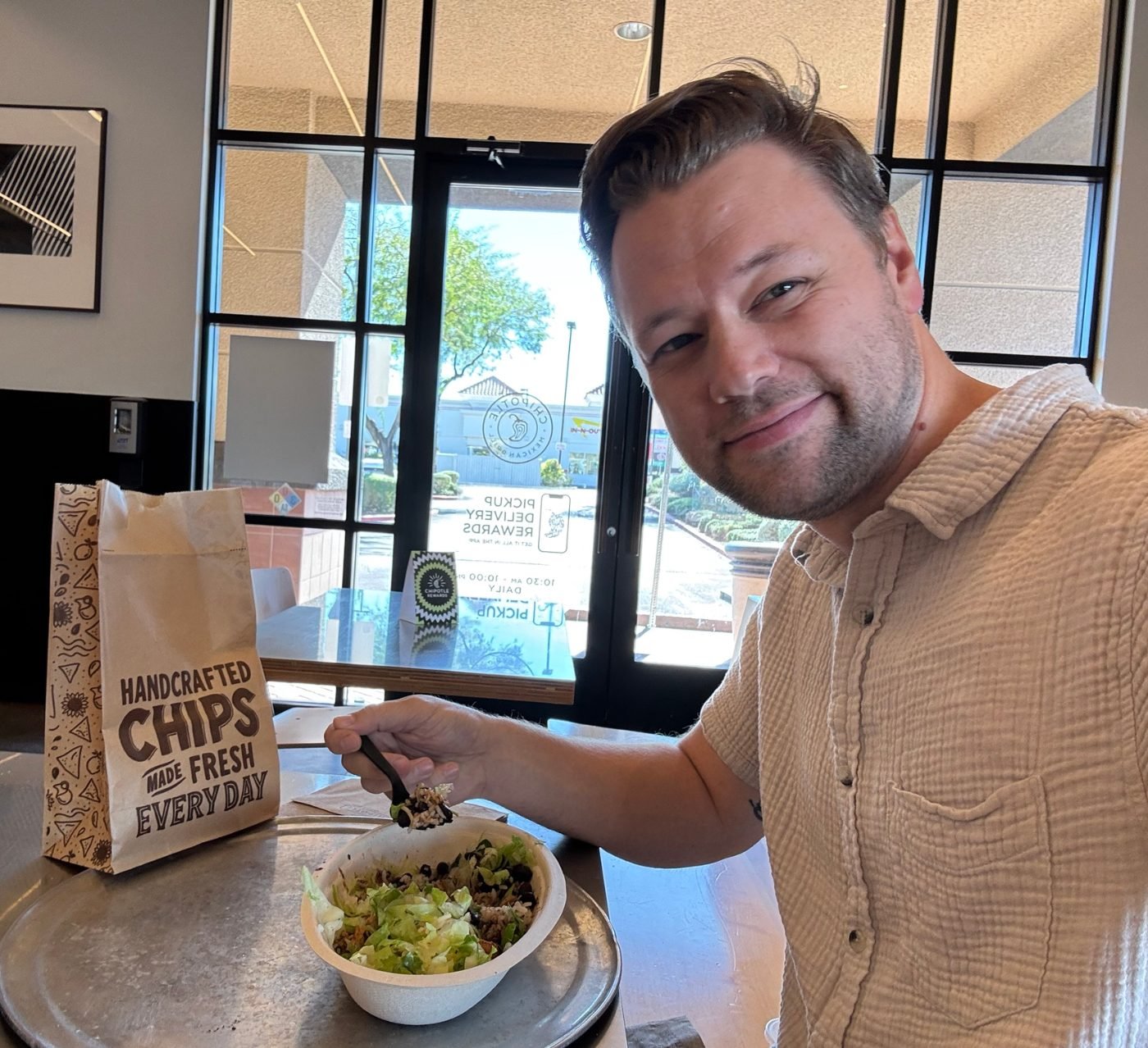 Ryan eating a burrito bowl at lunch, smiling at the camera
